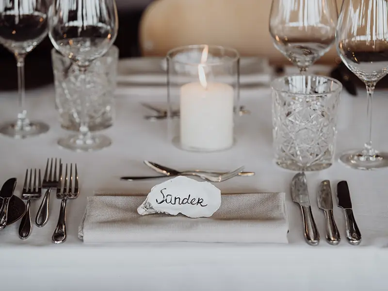 gedekte tafel voor een gast met een schelp als naambordje